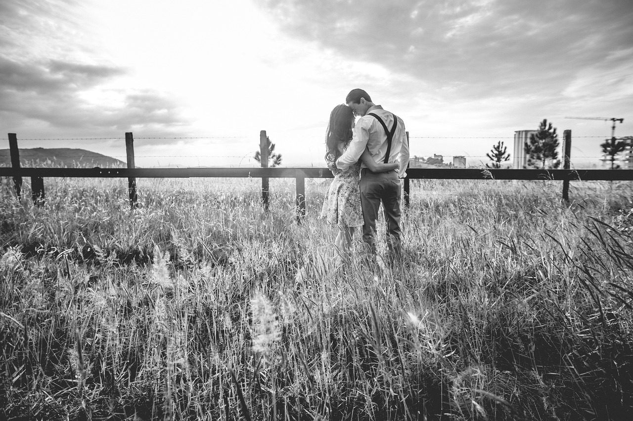 Couple de dos dans un champ en noir et blanc, illustration d'un chemin de vie respecté sans jugement après une perte ou un choix de non-parentalité